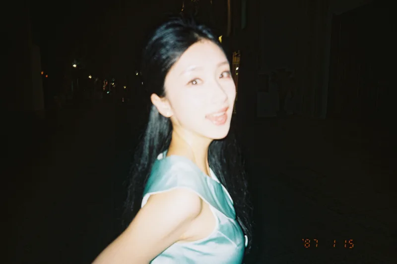 夜晚散步时，她穿着浅绿色裙子，回过头看向镜头