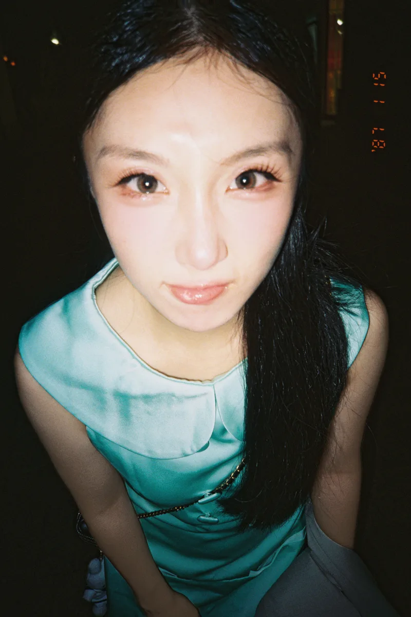 夜晚街边，她抬头望向镜头，留下一张近距离的竖幅照片